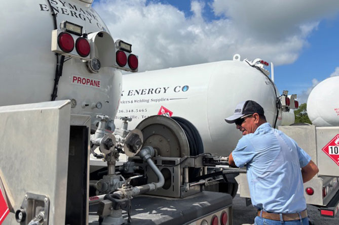 A man coiling a propane hose back into a truck
