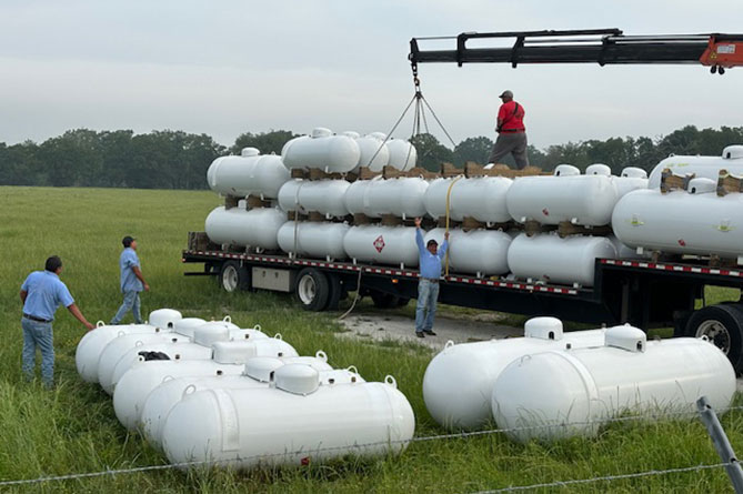 A large flatbed trailer with lots of propane tanks being moved